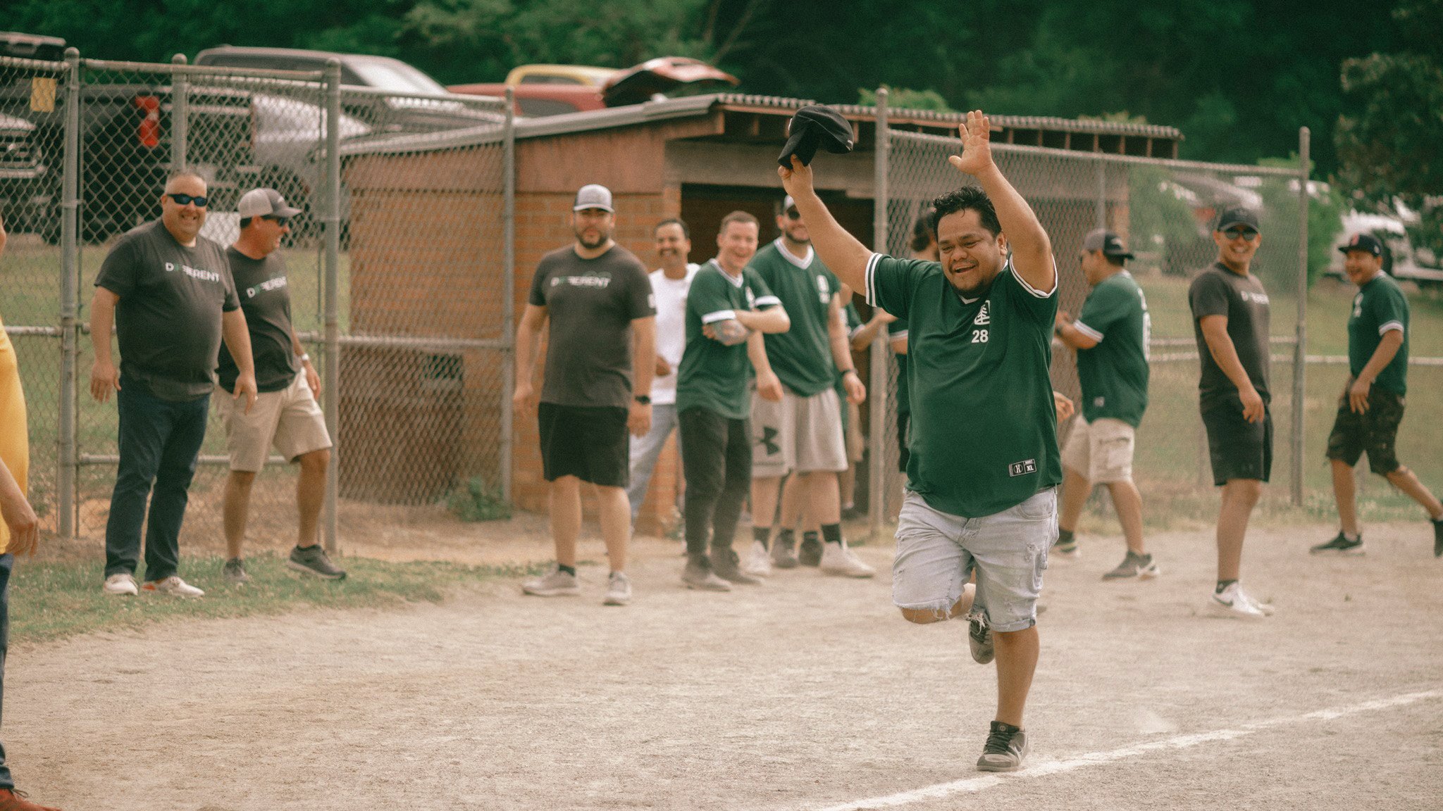 A company baseball game with a person running with their hands in the air
